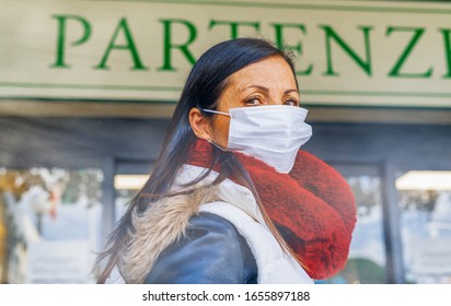 Coronavirus Alarm In Italy, Europe. Woman At The Airport Entrance Wearing Respirator Mask.