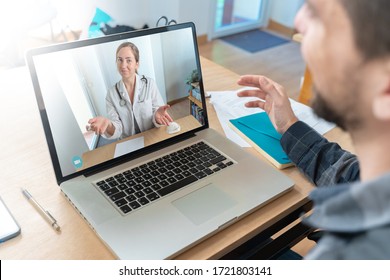 Coronavirus. Back View Of Man Making Video Call With His Doctor While Staying At Home. Close Up Of Patient In Video Conferencing With General Practitioner On Laptop. Sick Man Online Consultation. Home