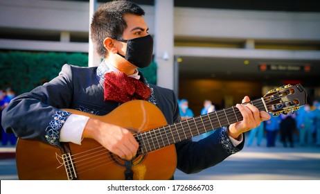 coronavirus Cinco De Mayo mariachi guitarist wearing a face mask plays at a hospital in Los Angeles for Doctors, nurses and all other healthcare workers.  During a pandemic in America May 2020 Summer