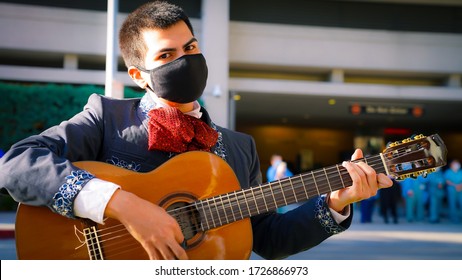 coronavirus Cinco De Mayo mariachi guitarist wearing a face mask plays at a hospital in Los Angeles for Doctors, nurses and all other healthcare workers.  During a pandemic in America May 2020 Summer