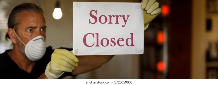 Coronavirus Closed For Business Concept, Man Business Owner With Medical Mask Puts Sorry Closed Sign On Window During Covid 19 Virus Pandemic, Cafe Shop Bankrupt, Covid-19 Restrictions And Lockdowns