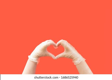 Coronavirus Concept Hands Wearing Latex Gloves Creating A Heart Shape On A Red Background