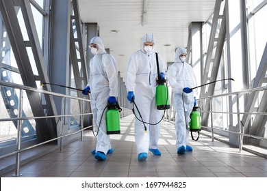 Coronavirus control. Team of professional virologists in protective suits ready for disinfection, covid-19, world pandemic - Shutterstock ID 1697944825