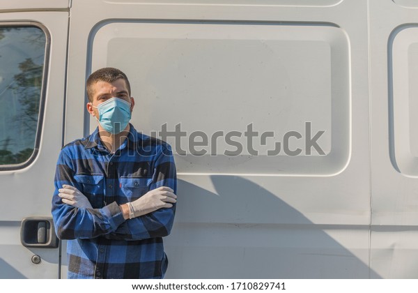 Coronavirus. Courier portrait in protective mask and\
rubber gloves make delivery service. Delivery service under\
quarantine, disease outbreak, coronavirus pandemic conditions.\
Transportation. Heroes.\
