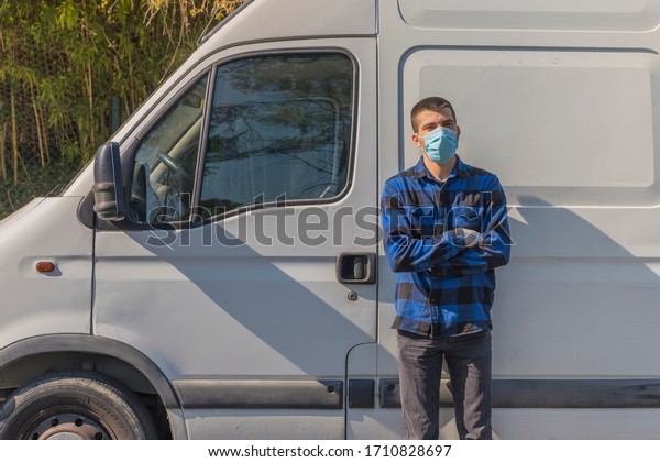 Coronavirus. Courier in protective mask and rubber\
gloves make delivery service. Delivery service under quarantine,\
disease outbreak, coronavirus pandemic conditions. Transportation.\
Heroes. Truck. 