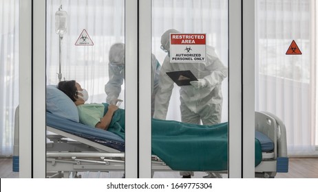 Coronavirus covid-19 Quarantäne- und Ausbruchwarnzeichen im Fenster des Quarantäneraums im Krankenhaus mit Seuchenbekämpfungsexperten versuchen, infizierten Patienten, die auf dem Bett liegen, eine Krankheitsbehandlung zu ermöglichen
