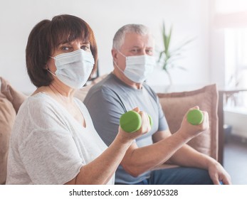 Coronavirus CoVid-19 Couple Old Aged Senior People At Home With Seasonal Cold Illness Disease Doing Exercise. Elderly Couple In Medical Masks During The Pandemic Sport