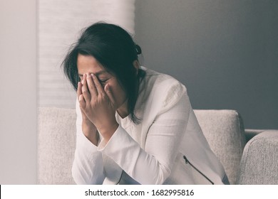 Coronavirus COVID-19 impact on retail businesses shut down causing unemployment financial distress. Depressed crying business woman stressed with headache.