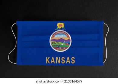 Coronavirus Covid-19 in Kansas U.S. state. Flag of the State of Kansas printed on medical mask on black background. Coronavirus update in Kansas City. State healthcare concept.	