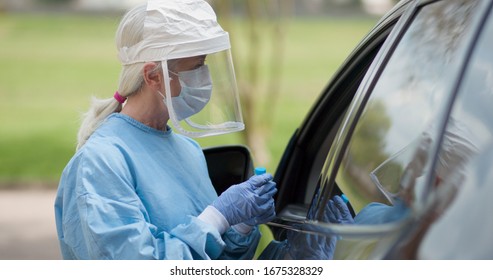 Coronavirus  or COVID19 mobile testing station healthcare worker in full protective gears finishes her task and walks toward the camera. - Shutterstock ID 1675328329