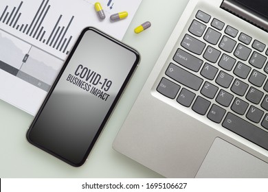 Coronavirus Covid-19 Pandemic Outbreak Business Impact Background Concept. Mockup Mobile Phone With Laptop, Business Charts And Medical Tablets On Working Table For Covid 19  Business Financial Risk.