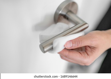 Coronavirus COVID-19 Prevention Cleaning Woman Wiping Doorknob With Antibacterial Disinfecting Wipe For Killing Corona Virus On Touching Surfaces Or Touching Public Bathroom Handle With Tissue.