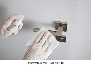 Coronavirus COVID-19 Prevention Cleaning Woman Wiping Doorknob With Antibacterial Disinfecting Spray For Killing Corona Virus On Touching Surfaces.