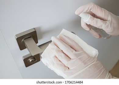 Coronavirus COVID-19 Prevention Cleaning Woman Wiping Doorknob With Antibacterial Disinfecting Spray For Killing Corona Virus On Touching Surfaces.