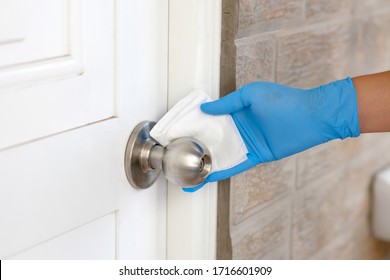 Coronavirus COVID-19 Prevention, Close up of hand cleaning doorknob with antibacterial disinfecting wipe for killing corona virus on touching surfaces handle with tissue - Shutterstock ID 1716601909