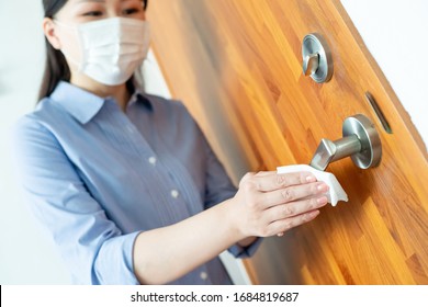 Coronavirus COVID-19 Prevention - Woman Wiping Doorknob On Touching Surfaces With Antibacterial Disinfecting Wipe For Killing Corona Virus 