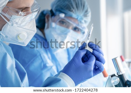 coronavirus covid-19 vaccine injection syringe in hands of pharmacuetical and vaccine research scientist in laboratory, coronavirus covid-19 vaccine development