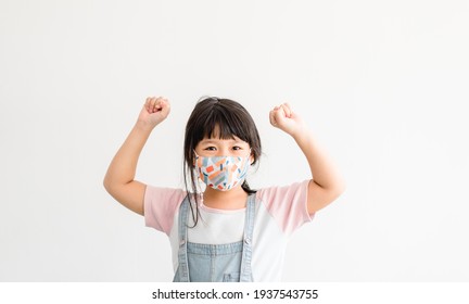 Coronavirus Covid-19.Online Education At Home.Asian Kid Girl Wearing Face Mask Raised Hand For Win Freedom Hope.Homeschool Kid During Covid19. Online Learning.back To School Distancing.New Normal.