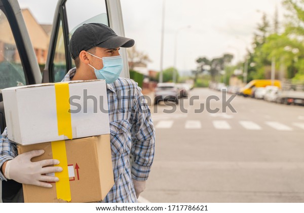 Coronavirus. Deliver man with protective mask and rubber
gloves make delivery service. Delivery service under quarantine,
disease outbreak, coronavirus pandemic conditions. Transportation.
Heroes. 