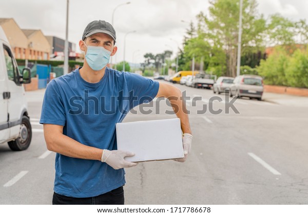 Coronavirus. Deliver man with protective mask and rubber\
gloves make delivery service. Delivery service under quarantine,\
disease outbreak, coronavirus pandemic conditions. Transportation.\
Heroes. 