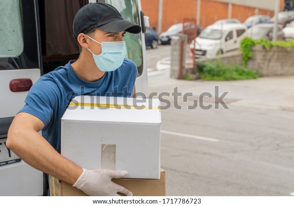 Coronavirus. Deliver man with protective mask and rubber
gloves make delivery service. Delivery service under quarantine,
disease outbreak, coronavirus pandemic conditions. Transportation.
Heroes. 