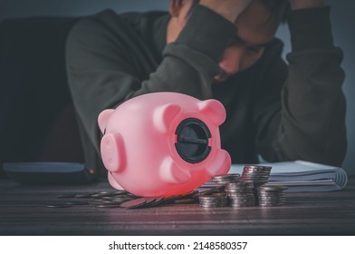 Coronavirus. Depressed And Concerned Businessman Due To The Impact On Retail Enterprises, Which Has Resulted In Job Losses And Financial Hardship Spend Less Money Quarantine Isolated Piggy Bank.