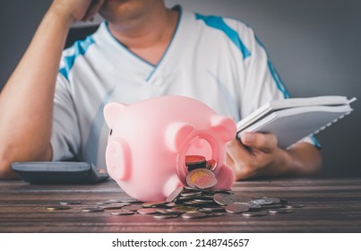 Coronavirus. Depressed And Concerned Businessman Due To The Impact On Retail Enterprises, Which Has Resulted In Job Losses And Financial Hardship Spend Less Money Quarantine Isolated Piggy Bank.