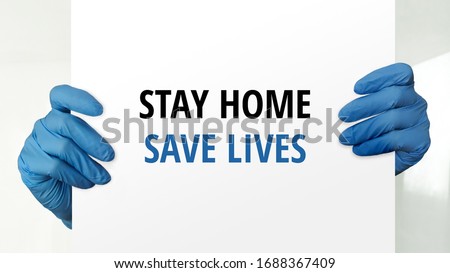 Coronavirus disease, COVID-19, social distancing, quarantine, self-quarantine, self-isolation concept. Stay home, save lives. Doctor's hands with blue protective  gloves holding paper with message. 