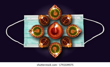 Coronavirus and Diwali 2020 concept. Face protective mask and illuminated diyas against black background. COVID19 spread prevention measure - Shutterstock ID 1792339075