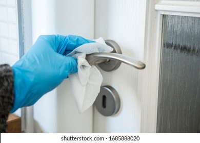 Coronavirus Epidemic Outbreak. Close-up of hand in protective glove using wet wipe to disinfect a handle.  - Shutterstock ID 1685888020