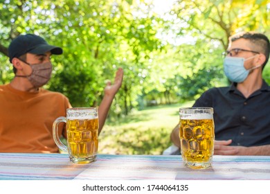 Coronavirus. Friends Making A Beer, Talking And Laughing In A Garden And Wearing Face Mask Protective. Social Distancing. Drink Safety. 