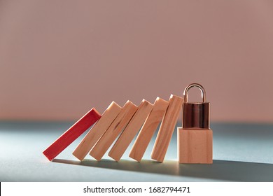 Coronavirus. Global crisis. Preventive measures. Global crisis. Wooden cube with padlock stopped domino effect. - Shutterstock ID 1682794471