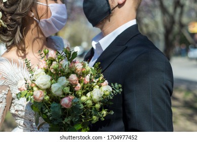 Coronavirus Infection Portrait Of A Masked Bride And Groom During A Wedding Ceremony. Oudoor. Weddings During The Period Of Quarantine And Pandemic Of Coronavirus Infection