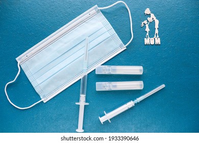 Coronavirus Infection Vaccination Concept. Medical Mask, Vaccine And Syringe 