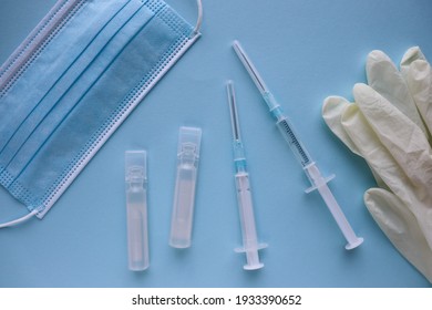 Coronavirus Infection Vaccination Concept. Medical Mask, Vaccine And Syringe 