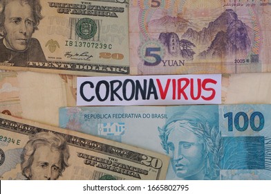 Coronavirus inscription on top of world international banknotes. Chinese Yuan, US dollars and Brazilian Real banknotes. Coronavirus alert. - Shutterstock ID 1665802795