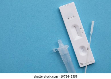 Coronavirus lateral flow home testing kit against a blue background - Shutterstock ID 1973448359