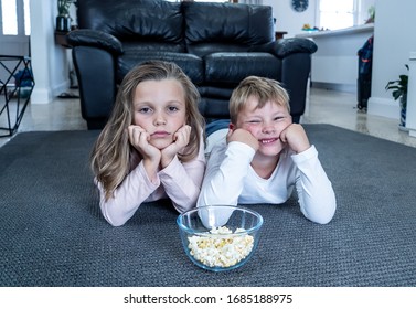 Coronavirus Lockdow. Bored Little Girl And Sad Boy Watching Tv In Isolation At Home During Quarantine COVID 19 Outbreak. Mandatory Lockdowns And School Closures Impact On Children Mental Health.