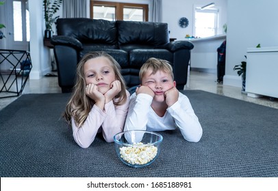 Coronavirus Lockdow. Bored Little Girl And Sad Boy Watching Tv In Isolation At Home During Quarantine COVID 19 Outbreak. Mandatory Lockdowns And School Closures Impact On Children Mental Health.