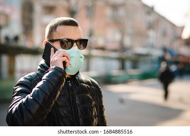 Coronavirus. Man Wearing Medical Protective Mask And Talking On Cell Mobile Phone, Walking On Street. Prevent Covid-19, Flu. Feeling Bad In City. Person Needs Help. Virus, Pandemic, Panic Concept.