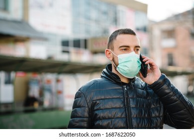 Coronavirus. Man Wearing Medical Protective Mask And Talking On Cell Mobile Phone, Walking On Street. Prevent Covid-19, Flu. Feeling Bad In City. Person Needs Help. Virus, Pandemic, Panic Concept.