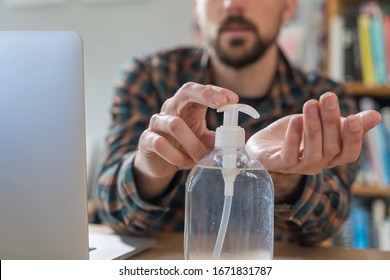 Coronavirus. Man working from home wearing protective mask. quarantine for coronavirus wearing protective mask. Working from home. Cleaning her hands with sanitizer gel.  Thermometer fever inspection. - Powered by Shutterstock