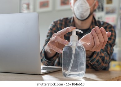 Coronavirus. Man working from home wearing protective mask. quarantine for coronavirus wearing protective mask. Working from home. Cleaning her hands with sanitizer gel.  Thermometer fever inspection.