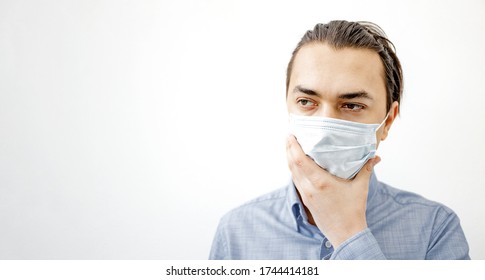 Coronavirus Mask. Sick Man In The Surgical Facemask Touching His Face On White Background. COVID-19 Advice: Don't Touch Your Face. Banner. Prevention Against Pandemic Coronavirus. White Background.