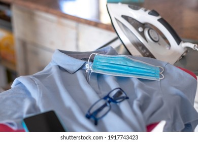 Coronavirus. The New Normal Combines Clothing And Accessories With The Colors Of Surgical Masks. Light Blue Men's Polo Shirt And Light Blue Medical Mask