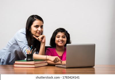 Coronavirus Outbreak and education concept - Lockdown and school closures. Indian Mother helping daughter studying online classes at home. COVID-19 pandemic forces children and teachers e-learning