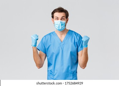 Coronavirus Outbreak, Healthcare Workers Fighting Disease, Hospitals Concept. Happy Doctor Cured Patient From Covid-19, Have Breakthrough. Smiling Wearing Medical Mask And Scrubs