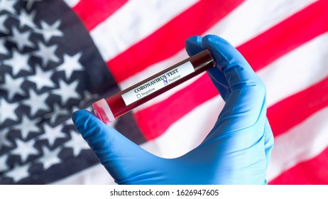 Coronavirus Outbreak In USA Concept. Nurse Hand In Gloves Holding Test Tube With Blood Over Flag Of The United States Of America. Blood Test For Novel Chinese Coronavirus 2019-nCoV