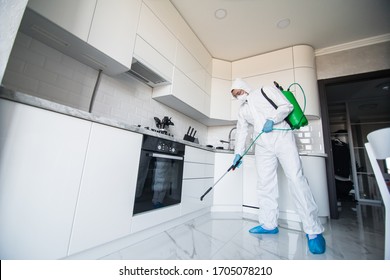 Coronavirus Pandemic. A disinfector in a protective suit and mask sprays disinfectants in house or office. Protection agsinst COVID-19 disease. Prevention of spreding pneumonia virus with surfaces. - Shutterstock ID 1705078210
