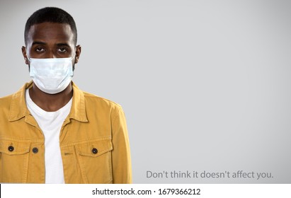 Coronavirus Pandemic. Serious Africanamerican Man In Medical Mask On A Gray Background With Space For Text And Slogan 